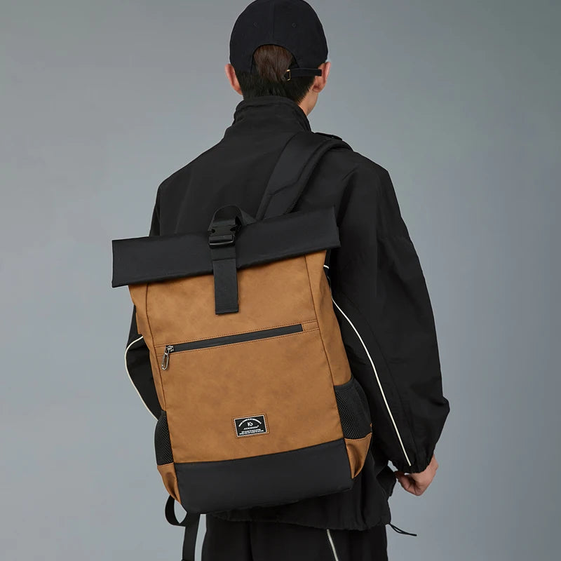 Man in black jacket wearing a brown roll-top backpack with black accents and front zipper