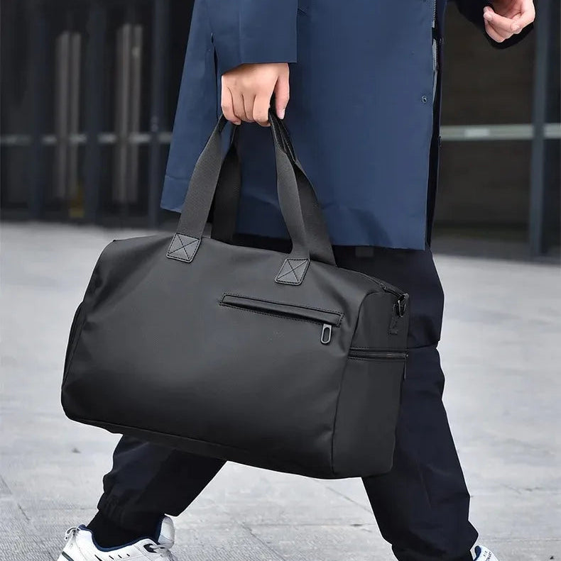 Man carrying sleek black duffel bag with zipper pocket, modern urban setting